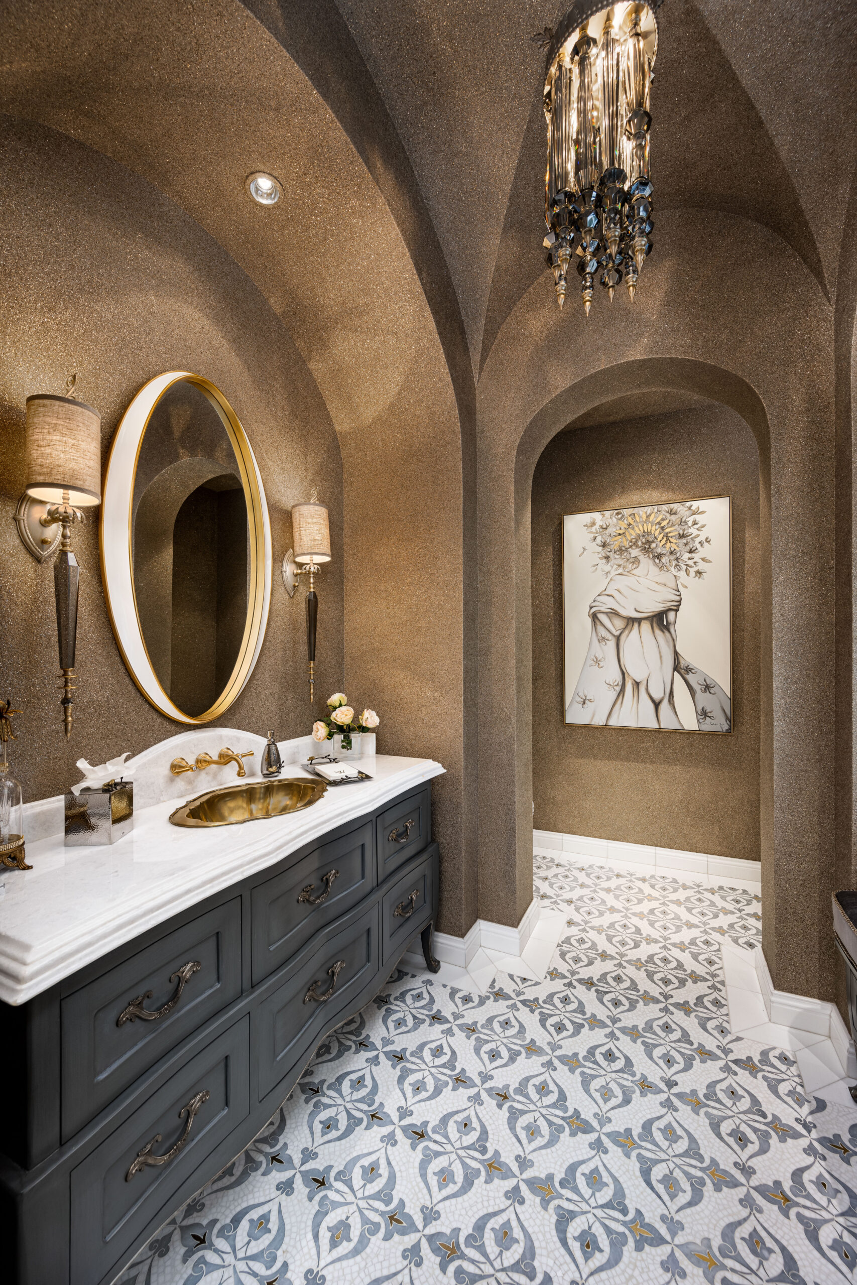Elegant Bathroom with Gold Accents: A luxurious bathroom with arched ceilings and walls covered in a shimmering gold texture. The vanity features a gold sink with a marble countertop and ornate gold fixtures. A round mirror with a gold frame is flanked by two wall sconces. The floor is tiled with a patterned design, and the space includes a decorative chandelier and artwork.